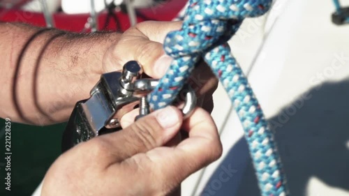 Crew hands on sailing ropes and hardware