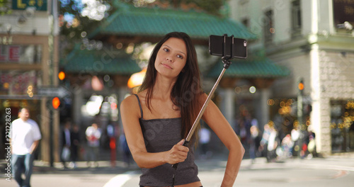 Trendy young tourist woman using selfie stick in Chinatown San Francisco
