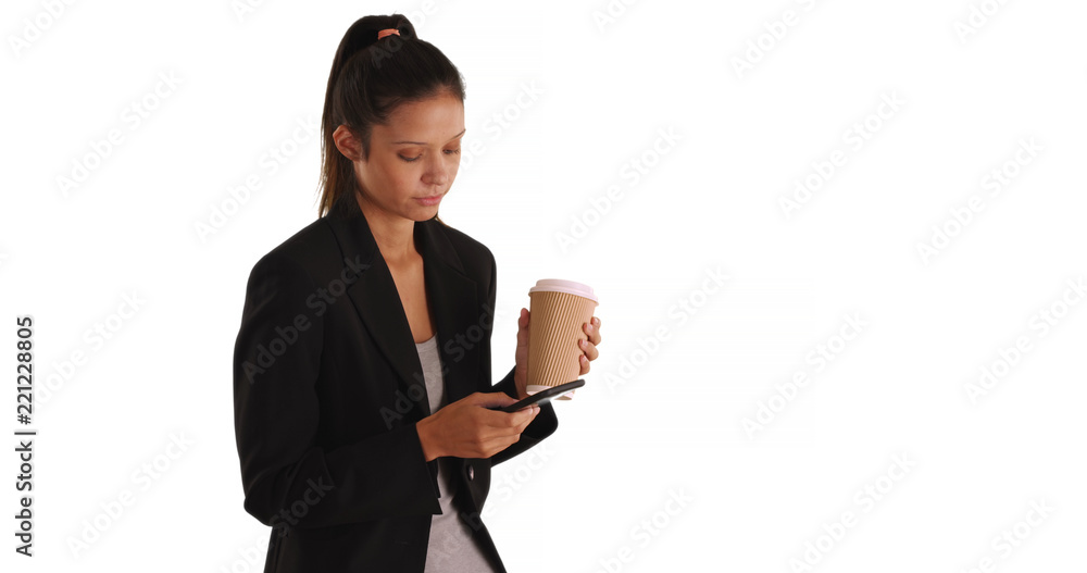 Business woman texting and holding paper to go coffee cup on white background Business woman texting and holding paper to go coffee cup on white background