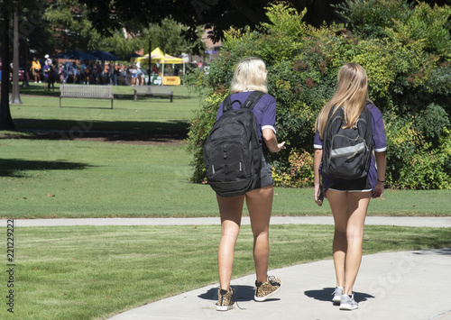 2 college girls walk through campus