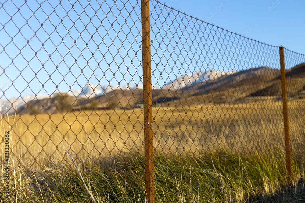 metal fence in the field at sunset metal fence in the field at sunset