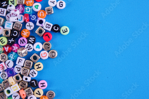 Colorful plastic alphabet dice on a blue background as a background. photo