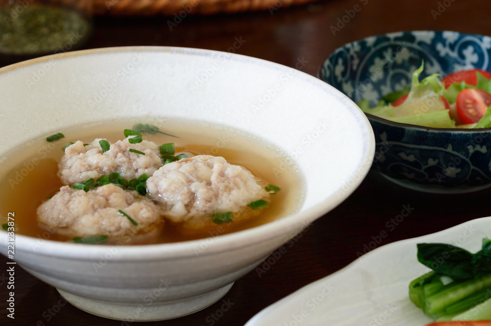 a bowl of Japanese style meat ball soup on a wooden table