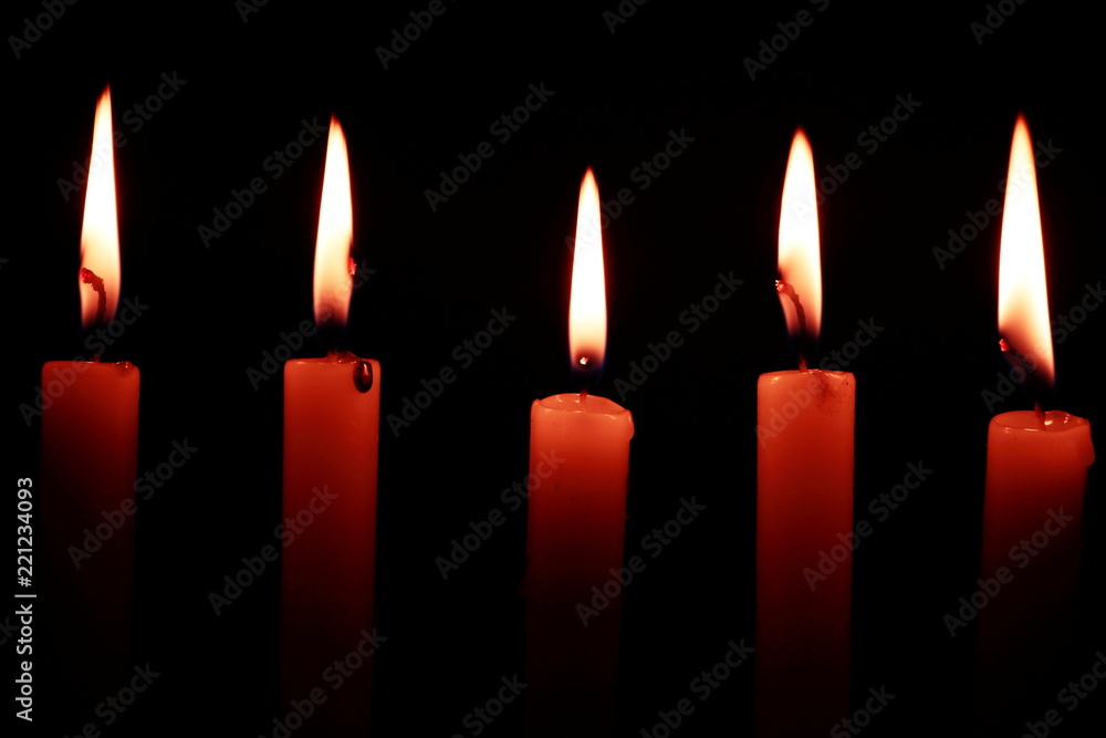 Several candles lit in the dark with the whole black background. Black background highlighting lighted candles leaving a super natural effect Several candles lit in the dark with the whole black background. Black background highlighting lighted candles leaving a super natural effect