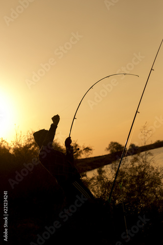 man is fishing at sunset