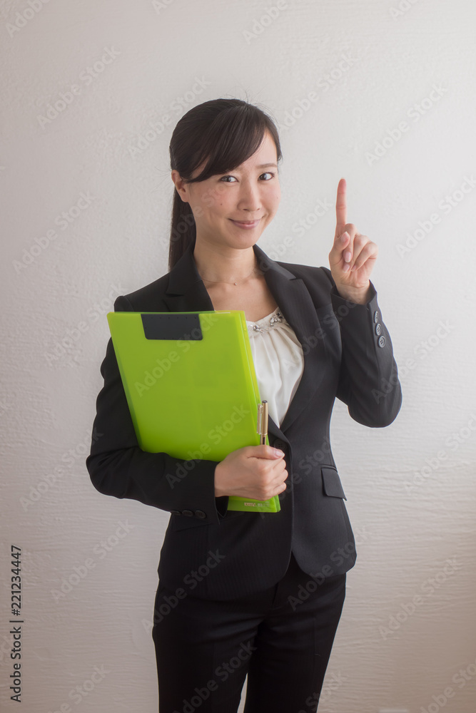 ファイルを持ち 指をさすポーズをするスーツ姿の女性 Stock Photo Adobe Stock
