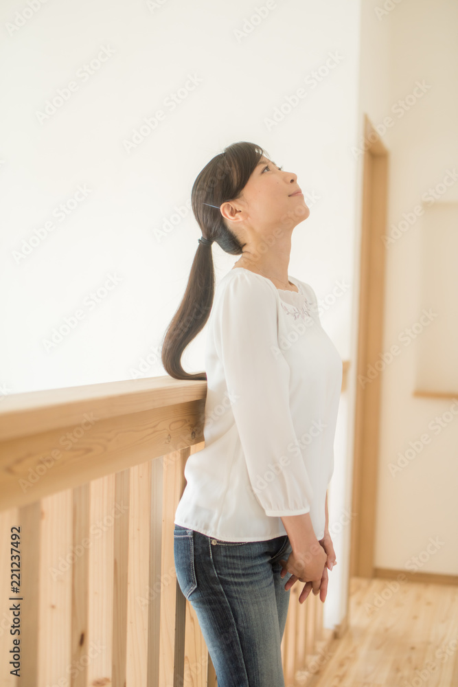 室内で上部を見上げる若い女性 室内で上部を見上げる若い女性