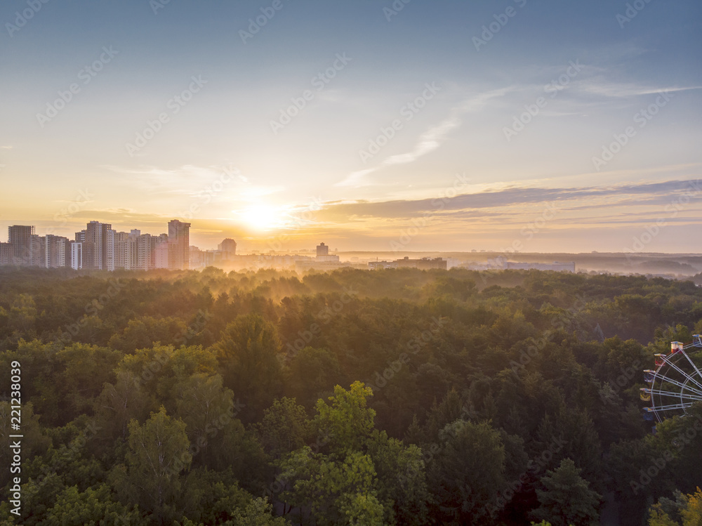 view of minsk from the park at sunrise time. golden rising sun in the background view of minsk from the park at sunrise time. golden rising sun in the background