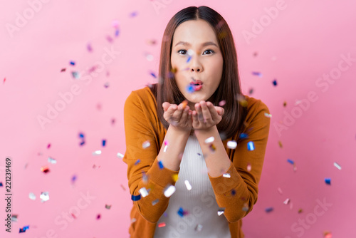 Cheerful beautiful girl She is blowing confetti.Celebrate on a special day