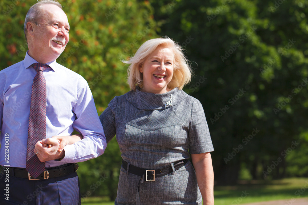 Senior couple walking in summer in park Senior couple walking in summer in park