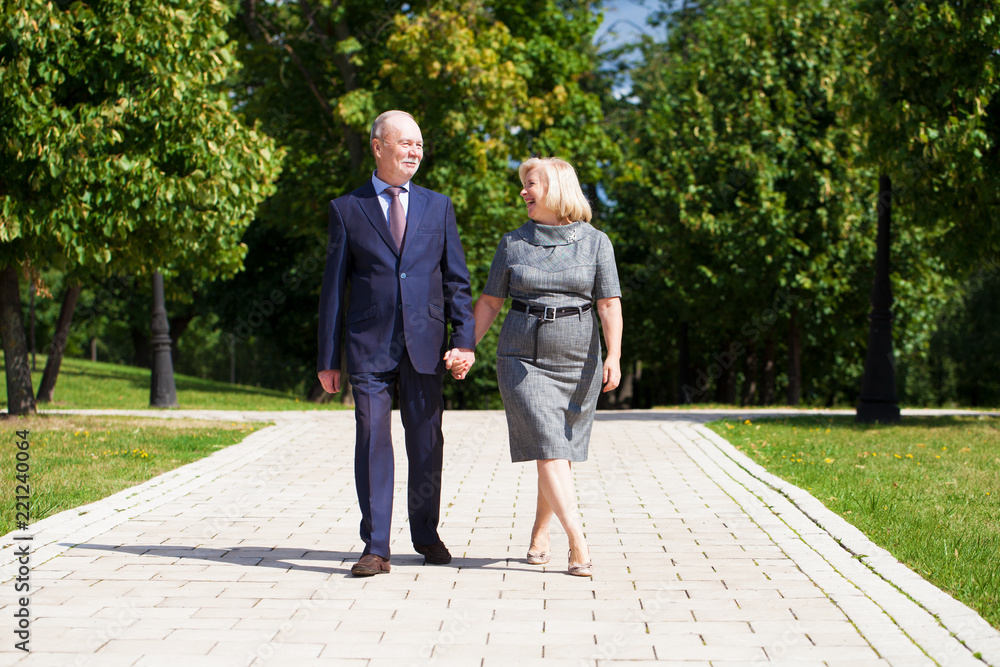 Senior couple walking in summer in park Senior couple walking in summer in park