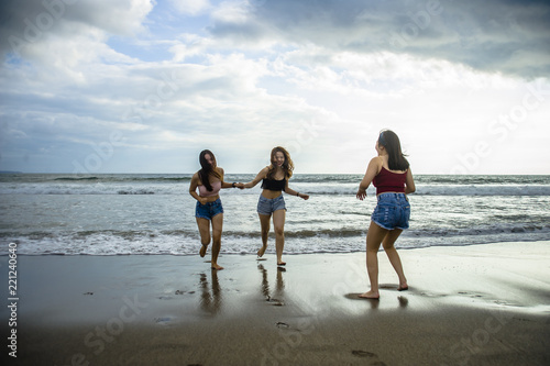 happy and excited young Asian Chinese women enjoying having fun on beautiful sunset beach in girlfriends summer holidays trip together and girls friendship concept