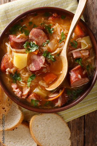 Czech traditional soup zelnacka of sauerkraut with sausages close-up in a bowl. vertical top view photo