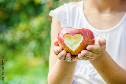 Child with an apple. Selective focus. Garden. photo