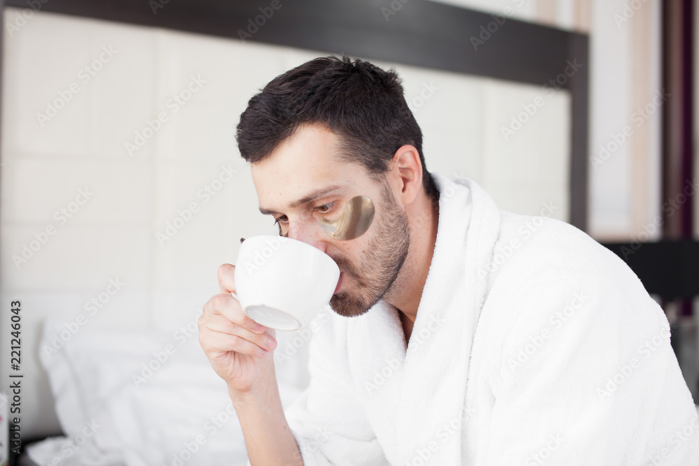 Handsome man drinking morning coffee in the bed Handsome man drinking morning coffee in the bed