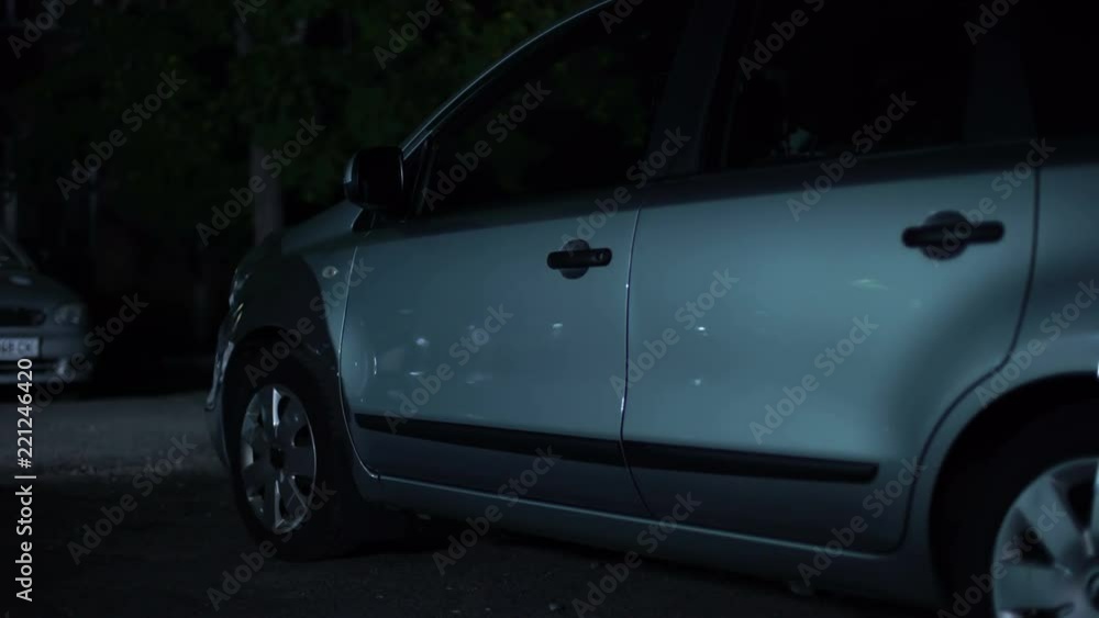 Shadow of gangster with gun walking on dark parking night, high-crime city area