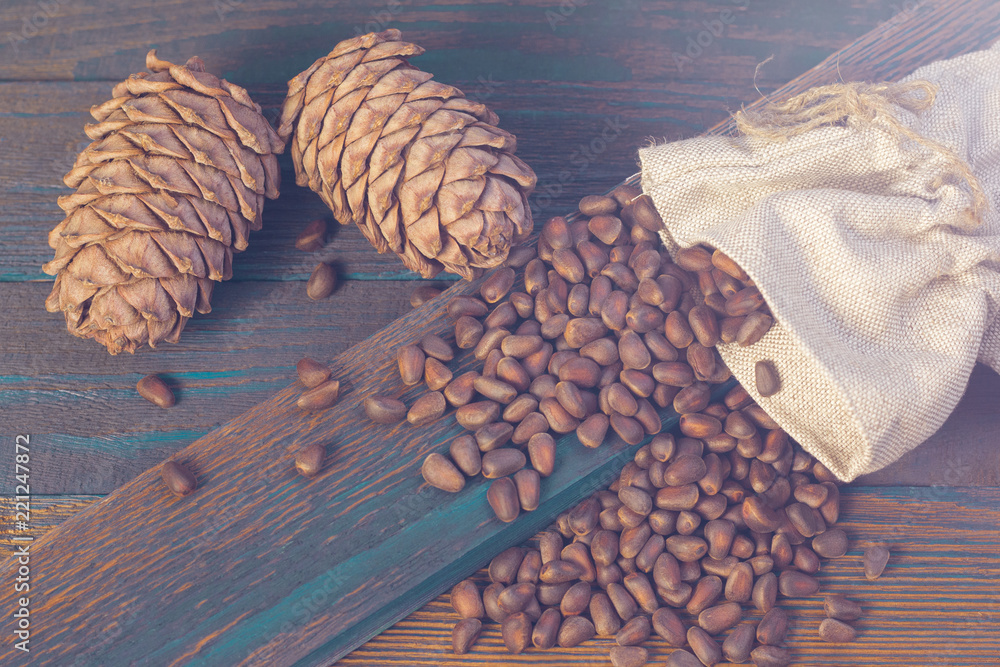 Cedar cones and nuts, poured from a bag on wooden boards. The source of