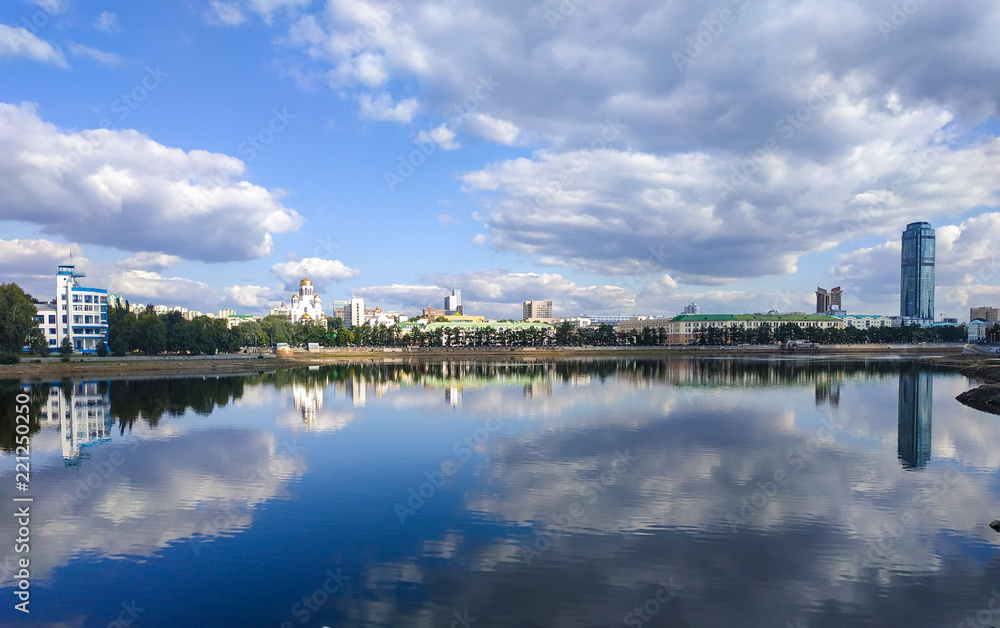 Reflection of autumn clouds in the Iset River in the center of Yekaterinburg - the capital of industrial Urals 