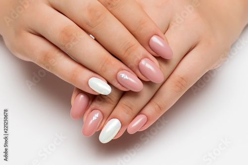 gently pink manicure with white pearly rub on long oval nails with crystals, rhombuses on a white background

