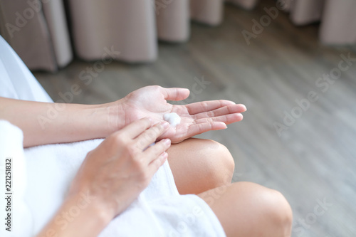 Woman applying moisturizing cream/lotion on hands, beauty concept. © BoszyArtis