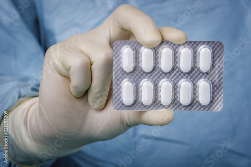 Close up scientist holding blister pack of pills photo