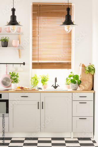 Fotografía Lamps above wooden countertop with plants in bright kitchen inte