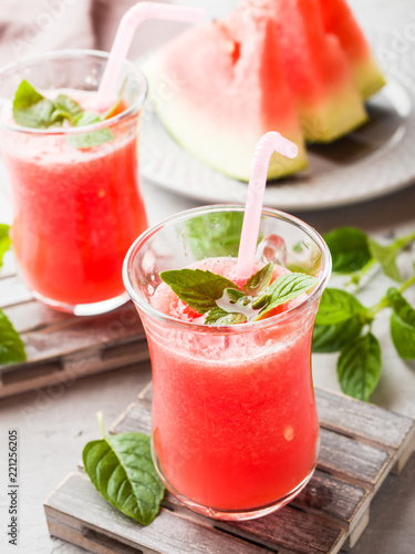 Fresh watermelon smoothie with ice and mint leaves in glasses.