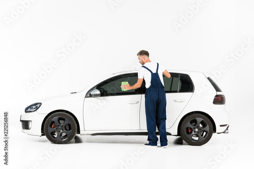 back view of auto mechanic cleaning car window after repairing on white © LIGHTFIELD STUDIOS