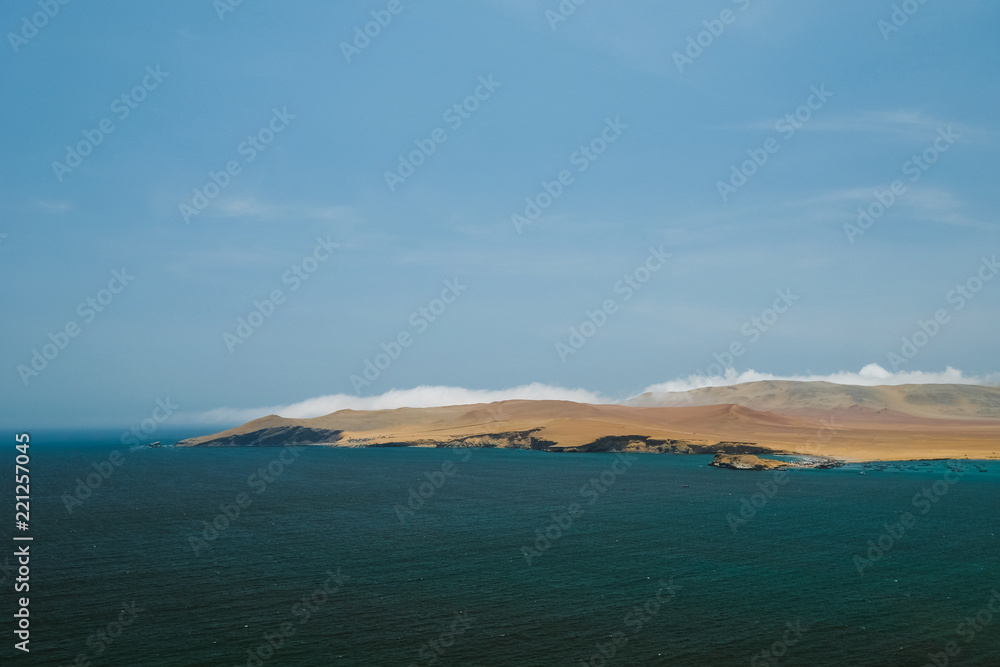 Natural reserve in Paracas, Peru. Blue sky, green sea, yellow cliffs, desert and ocean
