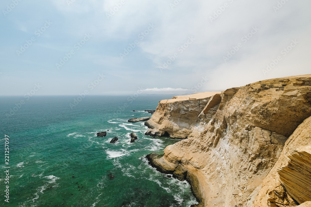 Peru, Paracas. Sandy rocks and ocean, sunny day