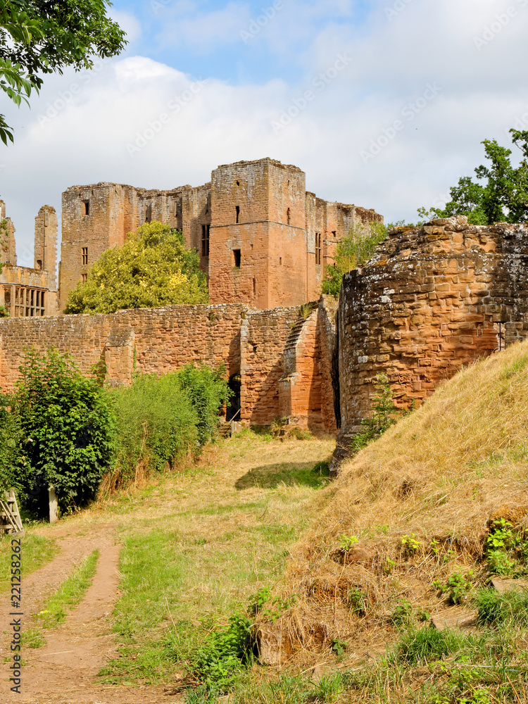 Fototapeta premium Kenilworth Castle ruins sheltered by a high defensive wall on a sunny day,