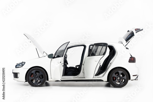 side view of new white car with open doors and open hood on white photo