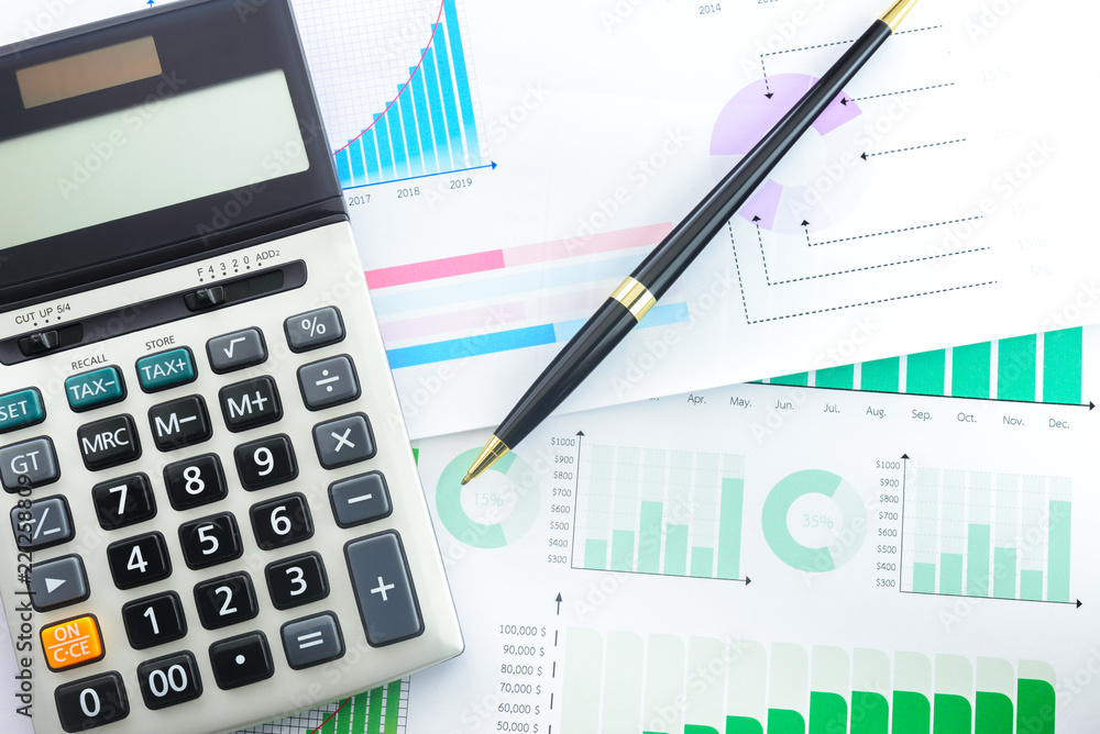 Calculator and Pen with Business Graphs finance document. Calculator and Pen with Business Graphs finance document.