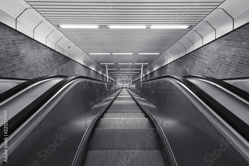 Black and white of descending escalator photo