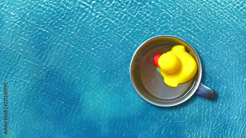 Фотография A toy duck floats in a mug. Isolation and tightness concept.