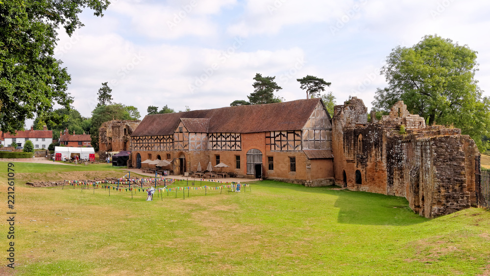 View of the ruins of Kenilworth Castle with a well-preserved stable on a sunny day,