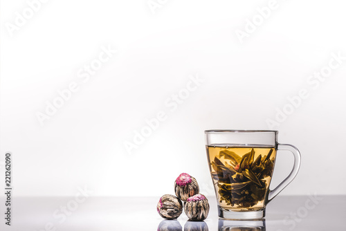 cup of chinese flowering tea with tea balls on table