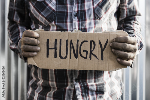 Homeless man holding hungry sign photo