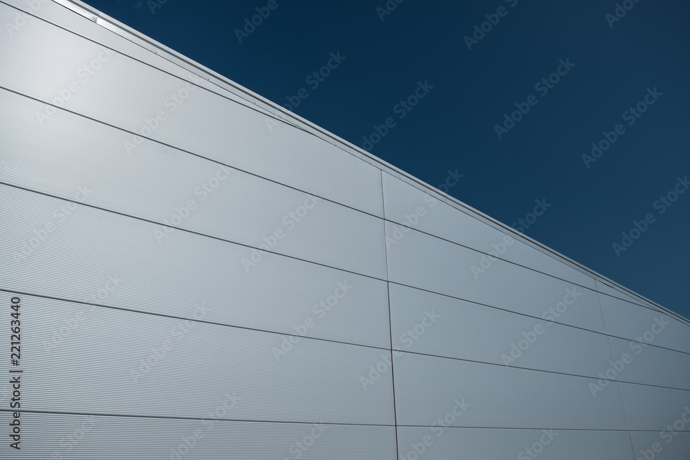 Modern building facade covered with steel sandwich panels in silver color Modern building facade covered with steel sandwich panels in silver color