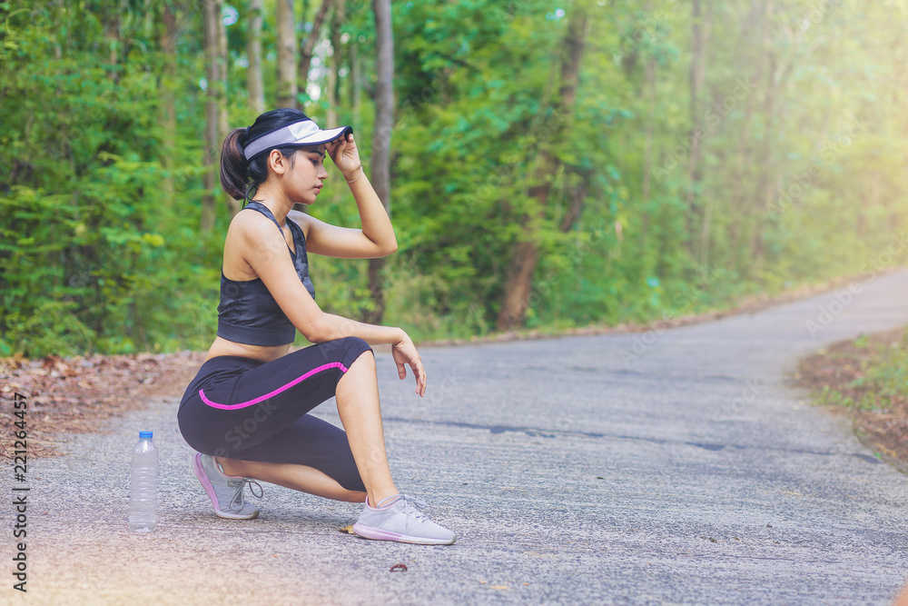 Woman runners sitting relax after jogging along path through the forest. Woman runners sitting relax after jogging along path through the forest.