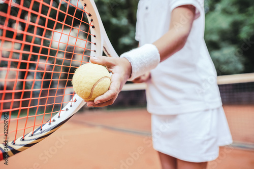 Sporty little girl preparing to serve tennis ball © HBS