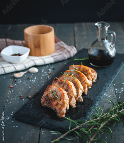 Roasted pork chops with fresh rosemary on dark background