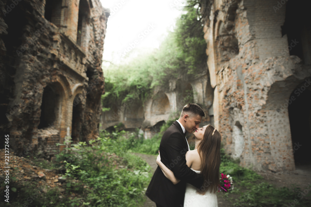 Happy newlyweds near the ancient castle on the walk Happy newlyweds near the ancient castle on the walk