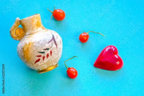 Red candy in the shape of heart  and small tomatoes photo