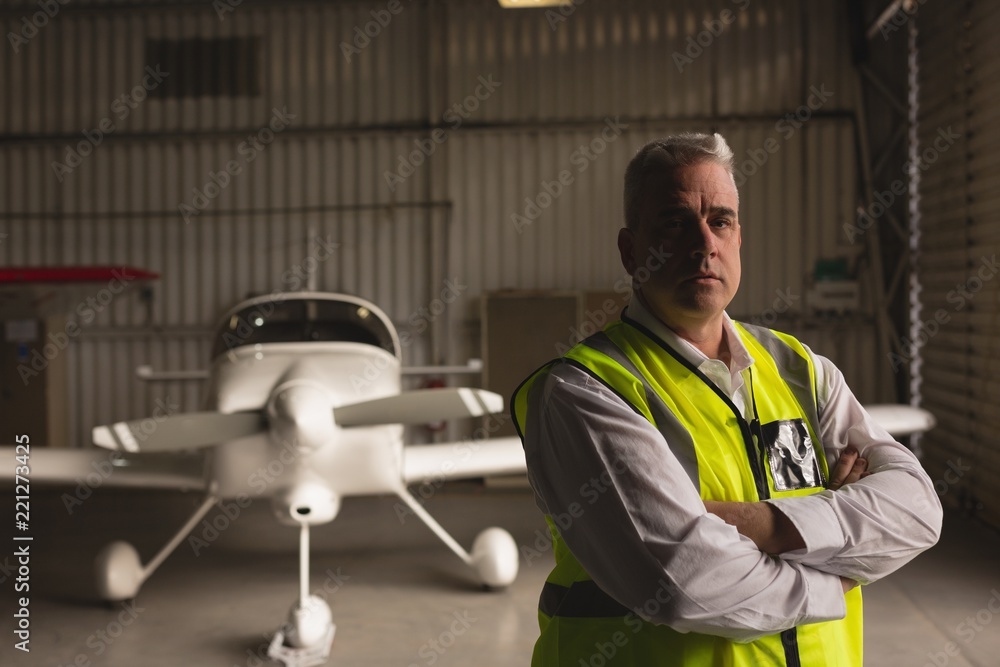 Engineer standing with arms crossed in hangar Engineer standing with arms crossed in hangar