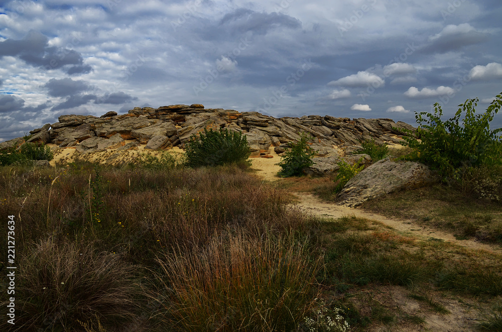 Large boulders in the Barrens lie on the sand amid the dark blue sky before the rain Large boulders in the Barrens lie on the sand amid the dark blue sky before the rain