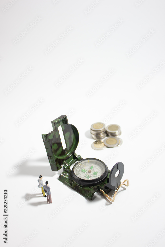 Miniature businessman with compass and coins verticle. Miniature businessman with compass and coins verticle.