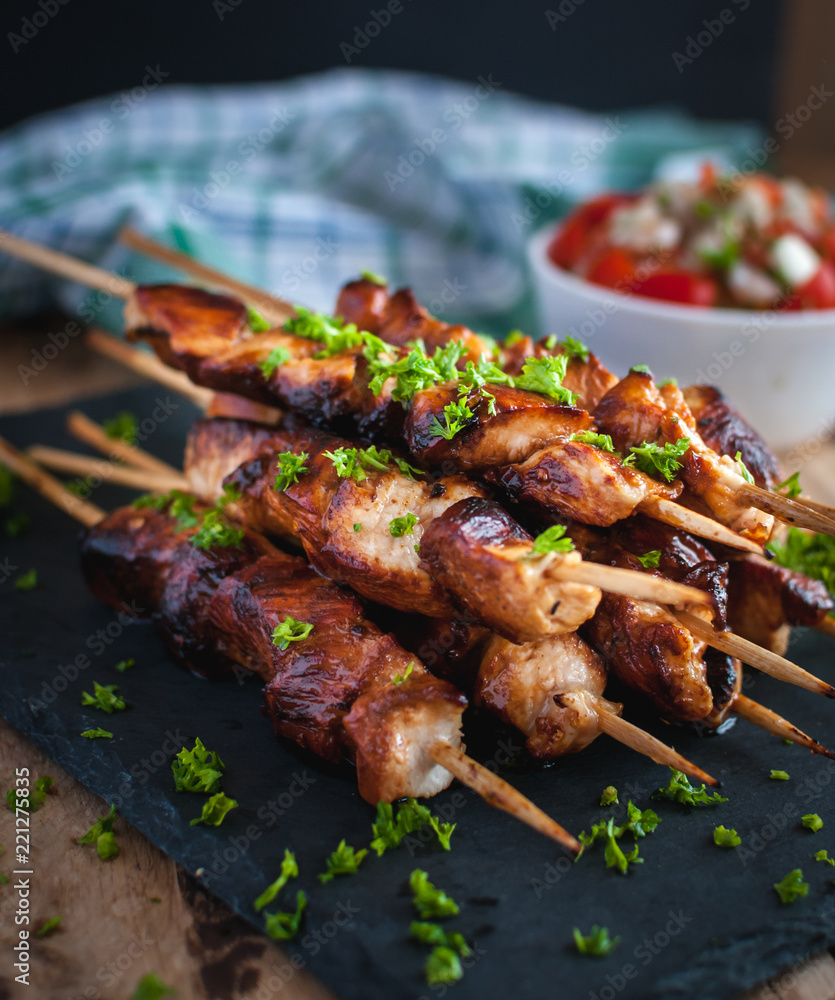 Close-up of homemade honey and beer BBQ chicken skewers with fresh parsley