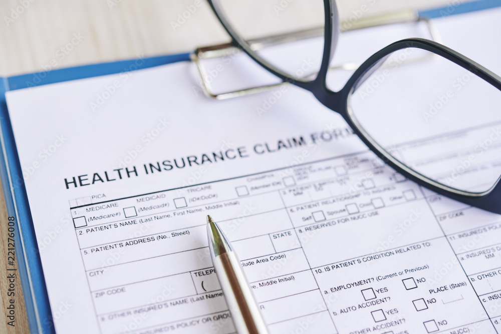 Health insurance claim form with glasses and pen Health insurance claim form with glasses and pen