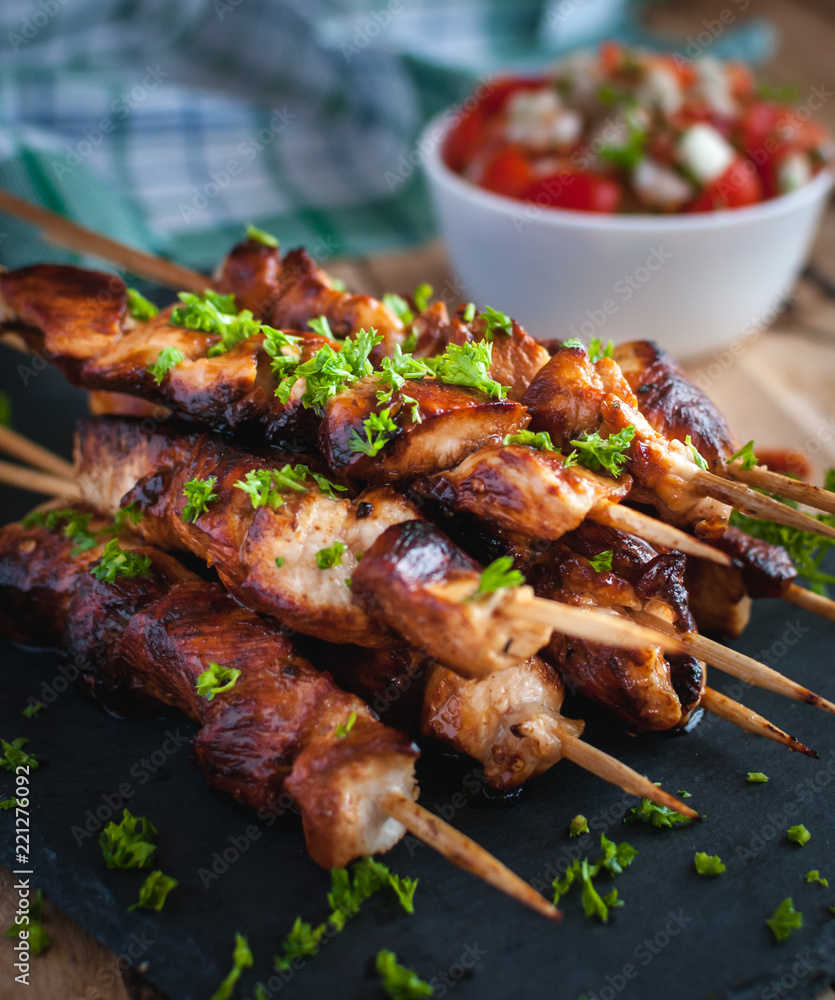 Close-up of homemade honey and beer BBQ chicken skewers with fresh parsley